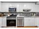 Modern kitchen features white cabinets, stainless steel appliances, granite countertops, and tiled backsplash at 22107 Harvest Ridge Ln # 22, Alpharetta, GA 30022