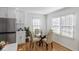 Charming dining room featuring a modern round table, new stainless steel appliances and natural light at 1652 Pine Cir, Austell, GA 30168
