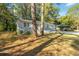Single-story home with carport surrounded by mature trees and lush landscaping at 1652 Pine Cir, Austell, GA 30168