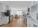 Open kitchen featuring white cabinetry, stainless appliances, and view to dining area at 1652 Pine Cir, Austell, GA 30168