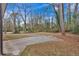 Expansive backyard featuring a large concrete parking pad surrounded by mature trees at 2344 Hollyridge Sw Dr, Marietta, GA 30060