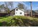 Expansive backyard featuring a lush lawn, screened porch, and fire pit seating area at 1309 Arnold Ne Ave, Atlanta, GA 30324