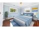 This bedroom features light blue walls, hardwood floors, a cozy bed, and natural light from the windows at 1309 Arnold Ne Ave, Atlanta, GA 30324
