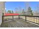 Wooden back deck overlooking the backyard with a red fence offering privacy at 1566 Wilson Manor Cir, Lawrenceville, GA 30045