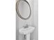 Modern half bath features pedestal sink, decorative mirror, and sleek faucet at 1566 Wilson Manor Cir, Lawrenceville, GA 30045