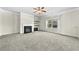 Cozy living room with fireplace, plush carpet, neutral paint, and modern ceiling fan at 1566 Wilson Manor Cir, Lawrenceville, GA 30045