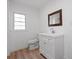Clean bathroom with a modern vanity, framed mirror, and hardwood floors at 172 White Rose Ln, Temple, GA 30179