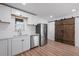 Modern kitchen featuring white cabinets, stainless steel appliances, and a rustic barn door at 172 White Rose Ln, Temple, GA 30179