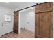 Mudroom entryway featuring a rustic sliding barn door and access to the laundry area at 172 White Rose Ln, Temple, GA 30179
