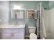 Charming bathroom with a single sink, white vanity, medicine cabinet, and shower with a patterned curtain at 3534 Brandywine Nw Rd, Kennesaw, GA 30144
