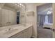 Bright bathroom with double sinks, a large mirror, and a doorway leading to the carpeted bedroom at 3534 Brandywine Nw Rd, Kennesaw, GA 30144