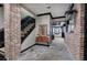 Elegant foyer with stone floors, exposed brick, decorative mirror, and stairs with black railings at 3534 Brandywine Nw Rd, Kennesaw, GA 30144