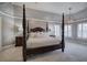 Well-lit main bedroom featuring a four-poster bed, decorative lighting, and plantation shutters at 3534 Brandywine Nw Rd, Kennesaw, GA 30144