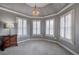 Sitting room illuminated by a chandelier, showcasing a bay of windows with plantation shutters at 3534 Brandywine Nw Rd, Kennesaw, GA 30144