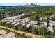 An aerial view showcases modern townhomes surrounded by mature trees with the city skyline in the background at 383 Pratt Se Dr # 503, Atlanta, GA 30315
