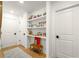 Hallway with wooden floors and open shelves featuring books and decor, next to two closed doors at 383 Pratt Se Dr # 503, Atlanta, GA 30315