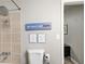Shower area featuring tiled walls, a chrome shower head, and witty wall decorations at 1351 Eason Nw St, Atlanta, GA 30314