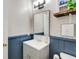 Stylish half bathroom with grey vanity, decorative wallpaper, and rustic wood shelf at 1351 Eason Nw St, Atlanta, GA 30314
