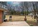 Backyard view of small wooden deck, mature trees, and an outdoor grill at 224 E Felton Rd, Cartersville, GA 30121