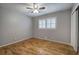 Clean bedroom features a ceiling fan, hardwood floors, and a large window at 224 E Felton Rd, Cartersville, GA 30121