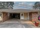 View of attached brick carport with concrete floor and door to a storage area at 224 E Felton Rd, Cartersville, GA 30121