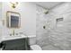 Bathroom featuring a vanity with marble countertop, gold hardware, and a tiled walk-in shower with a niche at 2316 Miriam Ln, Decatur, GA 30032