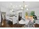 Modern kitchen featuring white cabinets, stainless steel appliances, and a large island with seating and adjacent dining area at 2316 Miriam Ln, Decatur, GA 30032