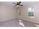 Bright bedroom featuring plush carpet, neutral paint, a ceiling fan, and a window overlooking the yard at 2775 Capri Dr, Cumming, GA 30041