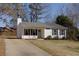 A well-maintained single-story home boasts white siding, a gray roof, and a neatly paved driveway at 2775 Capri Dr, Cumming, GA 30041