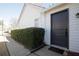 Exterior view of a dark gray front door with trimmed hedges along the sidewalk at 2800 Barnwood Xing, Duluth, GA 30097