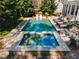 Beautiful in-ground pool and hot tub on a paver patio, surrounded by mature trees and lush greenery at 65 Gatewood Dr, Marietta, GA 30068