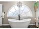 Bright bathroom featuring a soaking tub under a large arched window at 65 Gatewood Dr, Marietta, GA 30068
