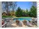 Beautiful backyard pool and patio area with lounge chairs, manicured landscaping, and serene outdoor setting at 65 Gatewood Dr, Marietta, GA 30068