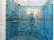 Spa-like shower featuring blue and green tiles, multiple shower heads, and a built-in bench at 65 Gatewood Dr, Marietta, GA 30068