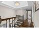 Beautiful staircase featuring hardwood steps, decorative iron railings, and a tray ceiling at 65 Gatewood Dr, Marietta, GA 30068