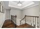 Elegant staircase with hardwood steps, intricate iron railings, and tray ceiling detail at 65 Gatewood Dr, Marietta, GA 30068