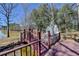 Scenic backyard deck overlooking a tranquil lake with a bridge and rock feature at 2382 Merrymount Dr, Suwanee, GA 30024