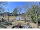 Lakeside backyard with mature trees and an outdoor recreation area at 2382 Merrymount Dr, Suwanee, GA 30024