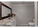 Half bath featuring a marble-style countertop, undermount sink, and decorative mirror at 2382 Merrymount Dr, Suwanee, GA 30024