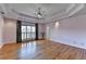 Spacious bedroom with tray ceiling, hardwood floors, and shuttered windows at 2382 Merrymount Dr, Suwanee, GA 30024
