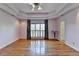 Large bedroom featuring hardwood floors, tray ceilings, and shuttered windows at 2382 Merrymount Dr, Suwanee, GA 30024