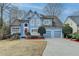 Inviting blue two-story home featuring a well-maintained front yard and attached two car garage at 2382 Merrymount Dr, Suwanee, GA 30024