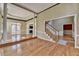 Bright foyer with hardwood floors, decorative columns, and staircase with natural light streaming in from the glass doors at 2382 Merrymount Dr, Suwanee, GA 30024