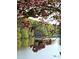 Scenic lakeside view with blooming trees and lush greenery, showcasing the property's natural beauty at 2382 Merrymount Dr, Suwanee, GA 30024