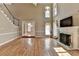 Spacious living room with fireplace, tall windows, and open access to the dining room, creating a harmonious living space at 2382 Merrymount Dr, Suwanee, GA 30024
