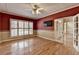 Bright living room with hardwood floors, large window with shutters, TV, and open french doors at 2382 Merrymount Dr, Suwanee, GA 30024