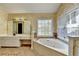 Bright main bathroom with a jetted tub, vanity with storage, and a large window at 2382 Merrymount Dr, Suwanee, GA 30024