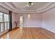 Spacious main bedroom features hardwood floors, tray ceilings, a ceiling fan, and lots of natural light at 2382 Merrymount Dr, Suwanee, GA 30024
