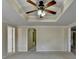 Main bedroom features a tray ceiling with a fan and a doorway to another room at 2382 Merrymount Dr, Suwanee, GA 30024