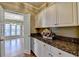 Stylish pantry boasts granite counters, ample white cabinets, and seamless transition to the living area at 2382 Merrymount Dr, Suwanee, GA 30024